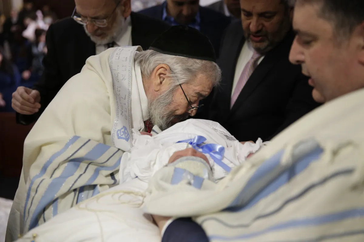 Sexual predator puts his mouth on the male baby's mutilated penis to suck the blood out.